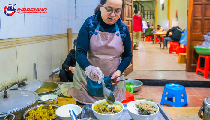 Enjoy traditional Au Tau porridge prepared by local chefs in a lush, green setting.
