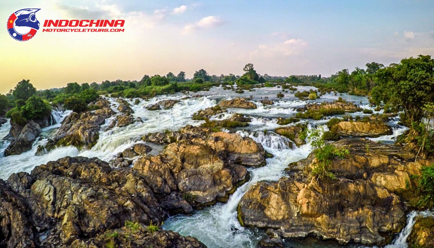 Motorbikers in Laos motorcycle tours  enjoying a serene ride along the peaceful waters of Si Phan Don