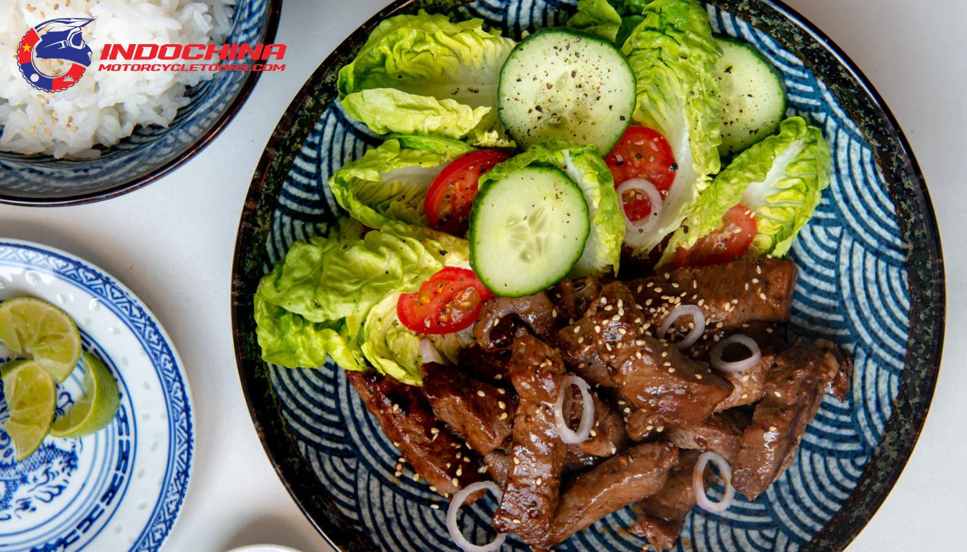 A stir-fried beef dish served with rice and a tangy dipping sauce