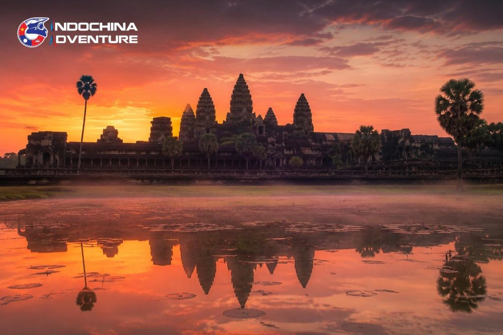 Angkor Wat temple reflected in the lotus pond at sunrise on a Cambodia motorbike tour