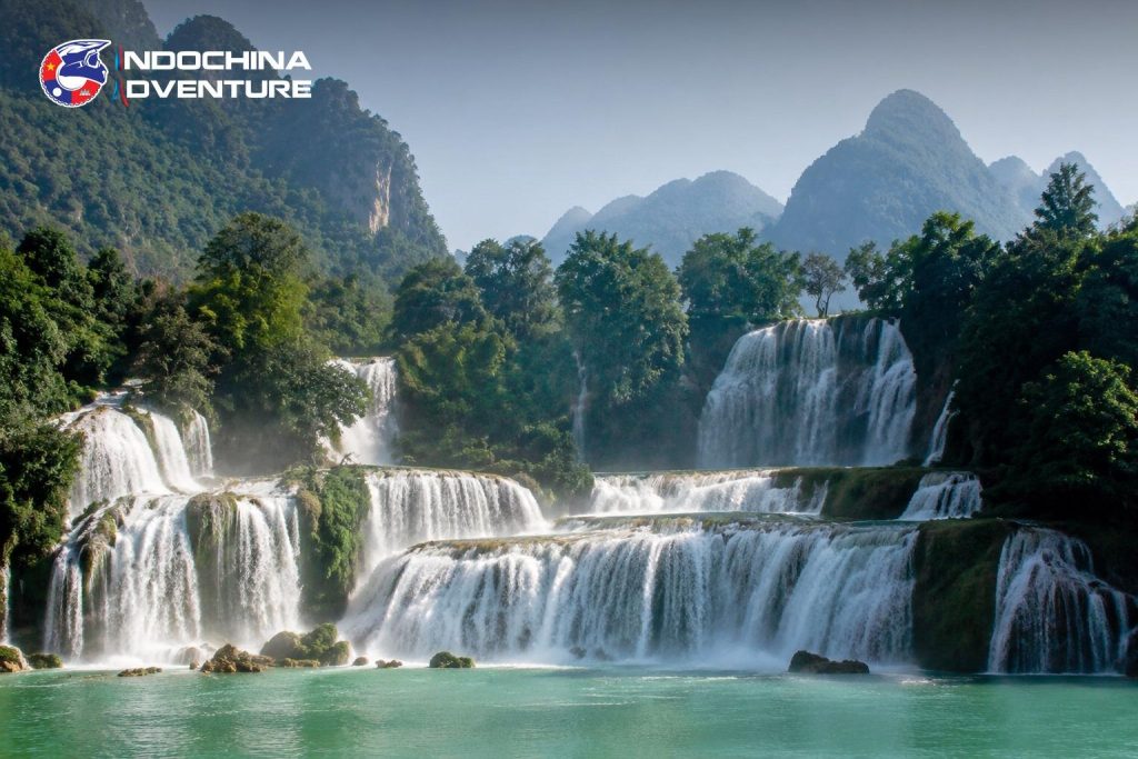 Wide tiered waterfall between limestone mountains on the Cao Bang to Ha Giang motorbike route