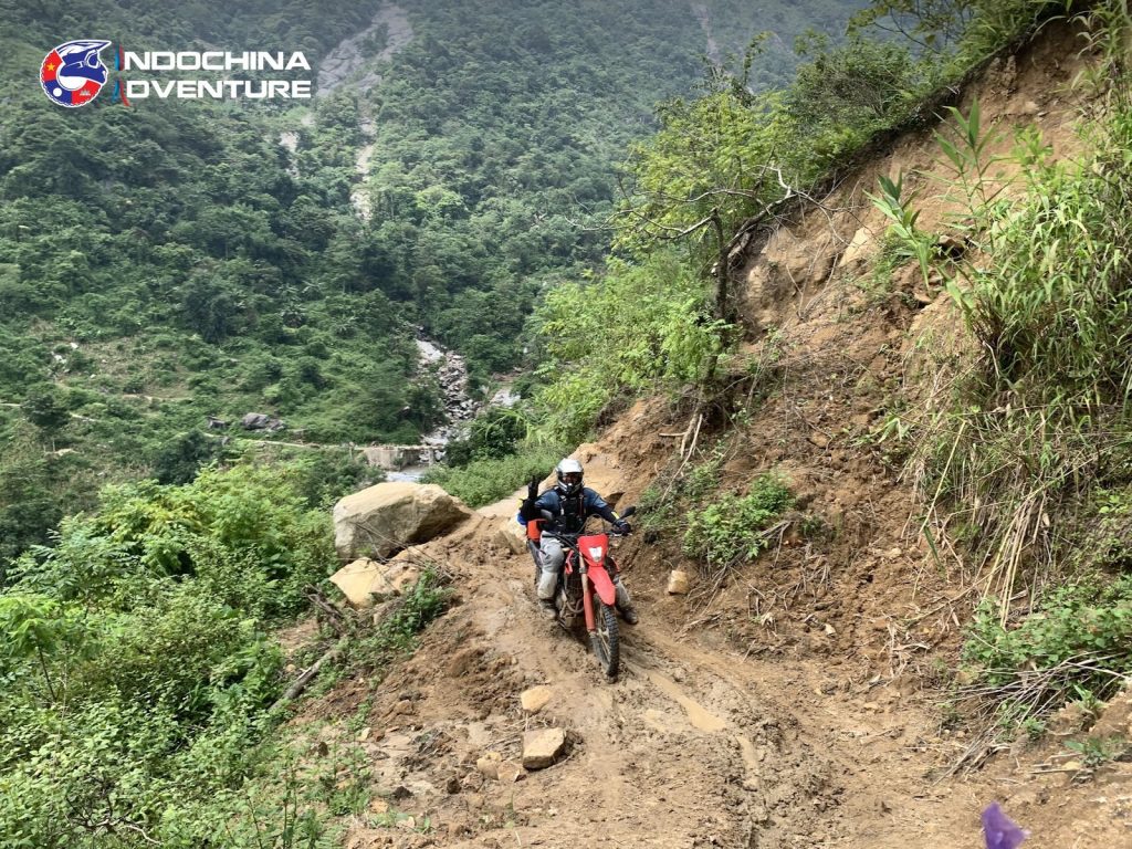 Dirtbike rider on a rough mountain track in the Truong Son range on a Vietnam offroad tour